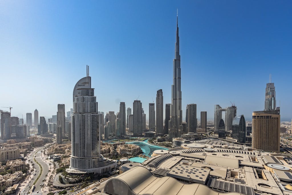 Home 15 Stunning aerial view of Dubai's modern skyline featuring the iconic Burj Khalifa under a clear blue sky.